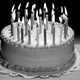 Black-and-white photo of birthday cake topped with candles